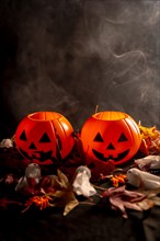 Halloween pumpkins on autumn leaves with smoke on a black background