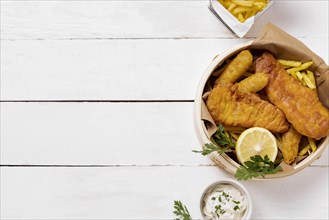 Top view fish chips bowl with lemon