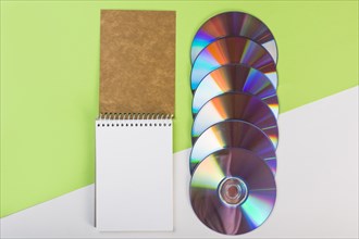 Spiral notepad with colorful compact discs green white dual background