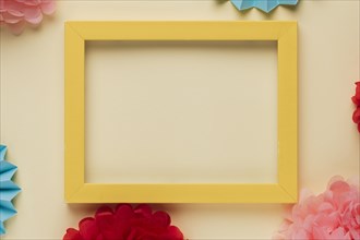 Yellow wooden border picture frame with decorated origami flowers