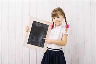 Charming girl pointing blackboard