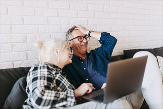 Elderly couple retirement home with laptop