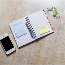 List notepad urgent sticky note checkered notebook with smartphone paperclip