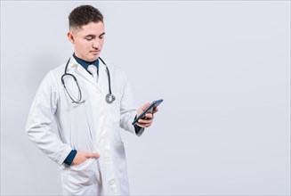 Young latin doctor holding telephone isolated. Handsome doctor using phone on isolated background