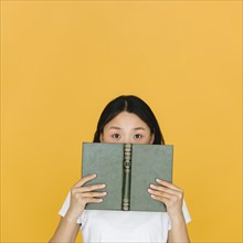 Young woman with book looking camera