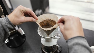 High angle male barista taking off coffee filter