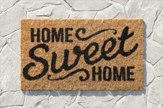 Overhead of home sweet home doormat on the rock tile porch