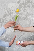 Woman s hand accepting yellow tulip rejecting pocket cigarette from man