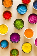 Holi color powder inside different type bowls concrete backdrop