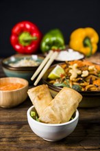 Fried spring rolls white bowl with thai food wooden desk