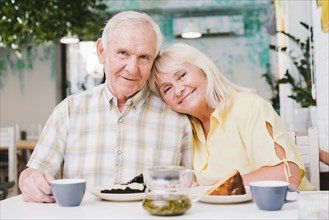 Loving elderly couple drinking tea eating cake