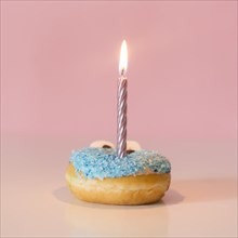 Front view donut with lit candle