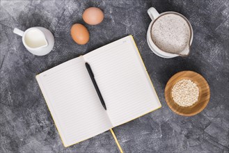 Bread ingredients with book pen concrete backdrop