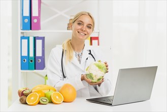 Medium shot smiley doctor with laptop cauliflower
