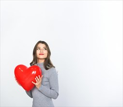 Young woman holding red heart balloon hands