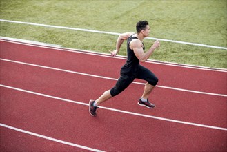 Male athlete arrives finish line racetrack during training session
