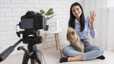 Female influencer home vlogging with dog