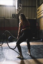 Woman working out with rope gym