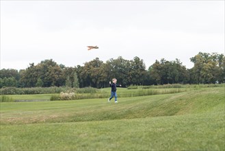 Boy playing with kite long shot