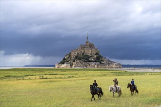 Horsemen in front of the monastery mountain Mont Saint-Michel