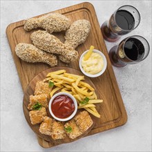 Flat lay fried chicken legs nuggets with fizzy drinks french fries
