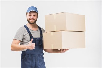 Delivery man with boxes showing thumb up
