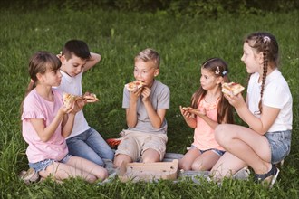Long shot kids eating slice pizza