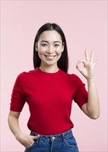 Smiley young woman showing ok sign