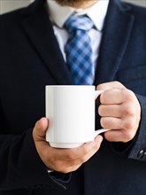 Elegant man holding up mug