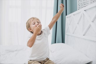 Little boy yawning after waking up