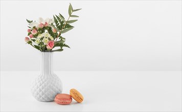 Vase with flowers macarons beside