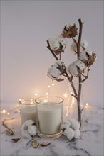 Candles decorated with cotton twig lighting equipments marble surface