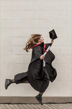 Side view girl jumping graduation