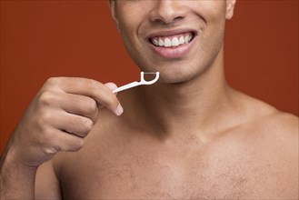 Young male using dental floss