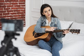 Young blogger teaching how play guitar