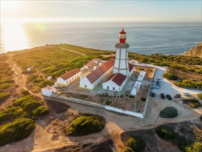 Aerial drone view of lighthouse on Cabo Espichel cape Espichel on Atlantic ocean at sunset. Sesimbra