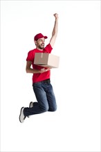 Young delivery man jumping holding box
