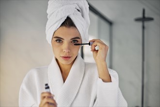 Beautiful woman using mascara