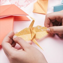 High angle view artist hand holding origami paper bird