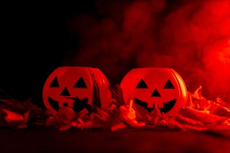 Detail of Halloween pumpkins on autumn leaves with smoke on a red background