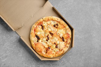 Top view of pizza with different types of cheese in cardboard box