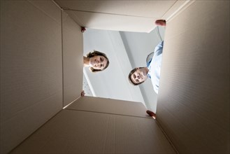 Couple looking inside empty box while packing move