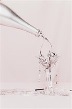 Champagne bottle pouring tinsel glass