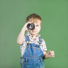 Boy holding camera lens eye