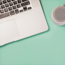 Close up bluetooth speaker laptop green background