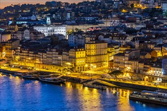 View over the river Douro to the Cais de Ribeira and the old town of Porto at dusk