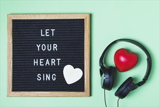 Message board red heart headphone green background