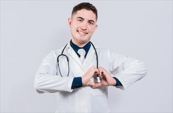 Young latin doctor making heart shape on isolated background. Friendly doctor making heart gesture with hands isolated