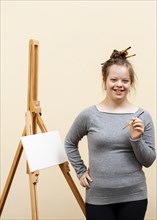 Smiley girl with down syndrome posing with brush