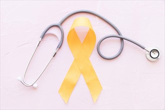 Sarcoma bone cancer yellow ribbon with stethoscope pink background